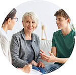 Una madre y su hijo hablan con una psicóloga durante una sesión de terapia familiar, Técnicas psicológicas en Torremolinos